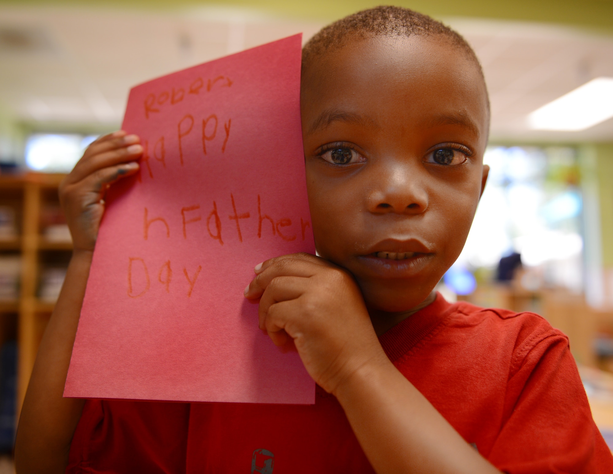 Robert Palmer, son of U.S. Air Force Master Sgt. Robert Palmer, 20th Security Forces Squadron NCOIC of training, holds a card he made for his father and says that his favorite thing about his dad is that he makes him laugh with the sound of his silly laugh when he finds something funny, Shaw Air Force Base, S.C., June 13, 2013. This Sunday, June 16 was Father’s Day a celebration honoring fathers and celebrating fatherhood, paternal bonds and the influence of fathers in society. (U.S. Air Force photo by Senior Airman Tabatha Zarrella/Released)