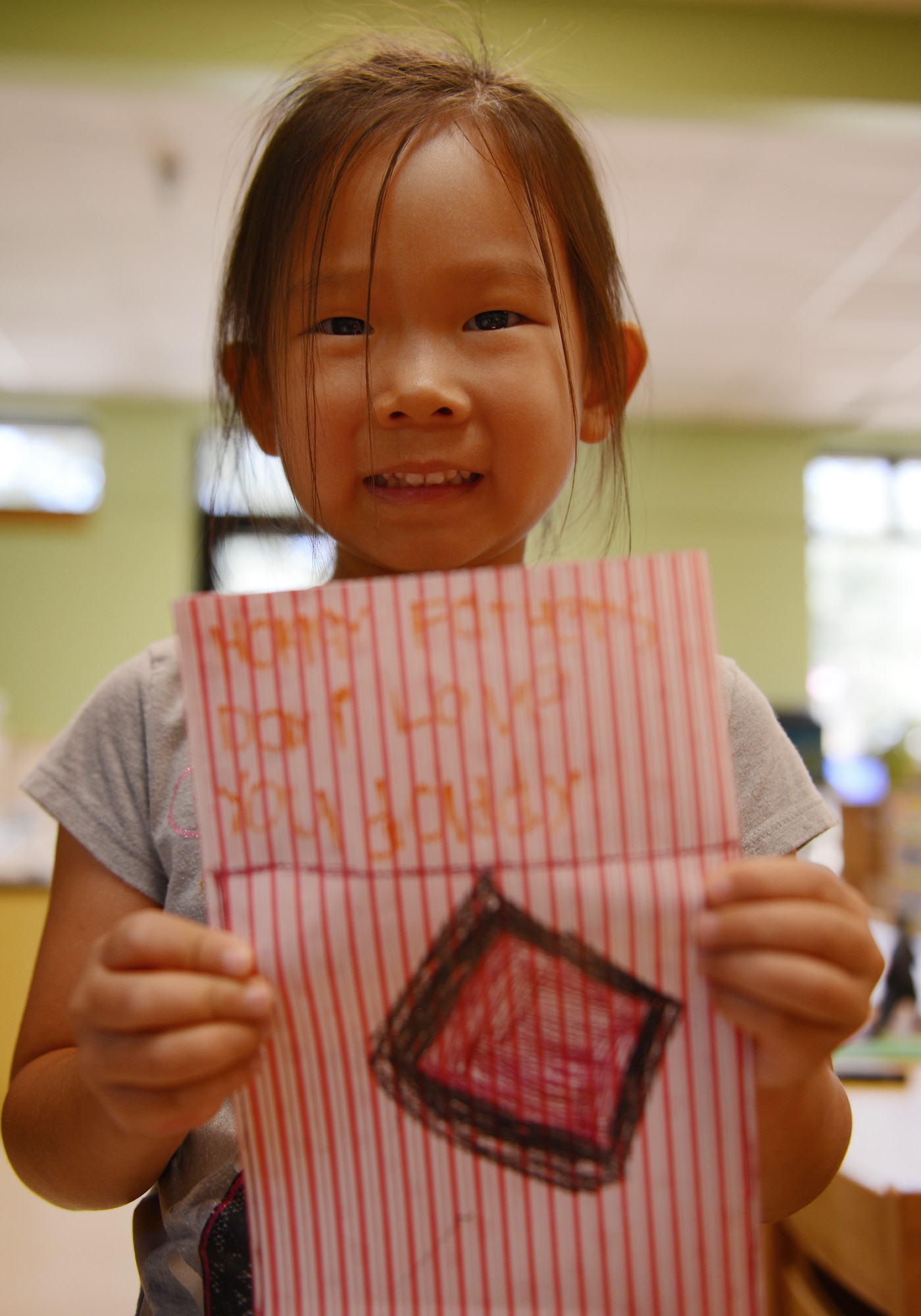 Kai Varitz, daughter of U.S. Air Force Lt. Col. James Varitz, 20th Fighter Wing chief of command post, holds a card she made for her father and says that she loves going to the pool with him, Shaw Air Force Base, S.C., June 13, 2013. This Sunday, June 16 was Father’s Day a celebration honoring fathers and celebrating fatherhood, paternal bonds and the influence of fathers in society. (U.S. Air Force photo by Senior Airman Tabatha Zarrella/Released)