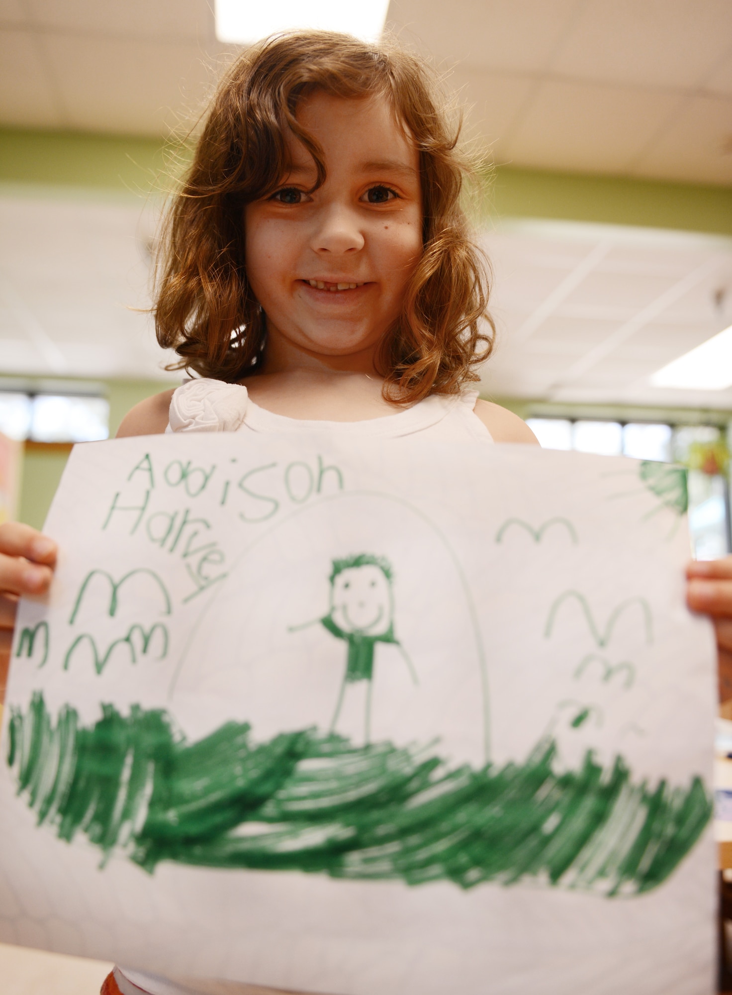 Addison Harvey, daughter of U.S. Air Force Tech Sgt. Shane Harvey, 20th Civil Engineering Squadron avionics intermediate section production superintendent, holds a picture she made of her dad and says that she loves when he reads her bedtime stories and tucks her in, Shaw Air Force Base, S.C., June 13, 2013. This Sunday, June 16 was Father’s Day a celebration honoring fathers and celebrating fatherhood, paternal bonds and the influence of fathers in society. (U.S. Air Force photo by Senior Airman Tabatha Zarrella/Released)