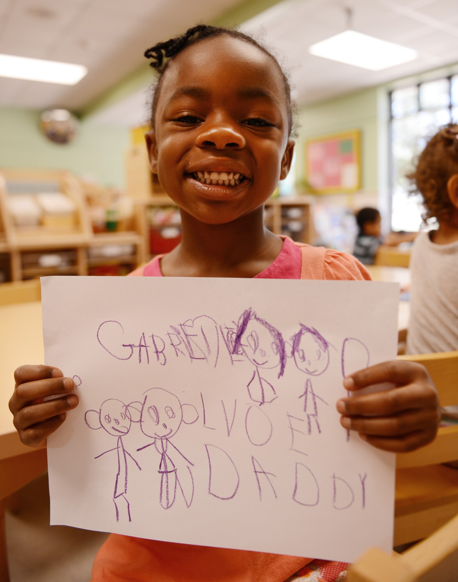 Gabriel Smith, daughter of U.S. Air Force Chief Master Sgt. Peter Smith, 20th Logistics Readiness Squadron distribution flight superintendent, and Capt. LaToya Smith, U.S. Air Force Central chief financial management analysis, holds a picture she made of her and her father and said that her dad makes her laugh really hard when he tickles her, Shaw Air Force Base, S.C., June 13, 2013. This Sunday, June 16 was Father’s Day a celebration honoring fathers and celebrating fatherhood, paternal bonds and the influence of fathers in society. (U.S. Air Force photo by Senior Airman Tabatha Zarrella/Released)
