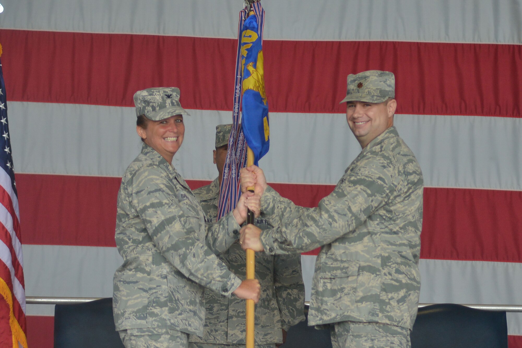 U.S. Air Force Col. Helen Brasher, 20th Maintenance Group commander, passes the unit guide-on to Maj. Michael Fields, incoming commander for the 20th Maintenance Group, Shaw Air Force Base, S.C., June 17, 2013. Changes of command are military tradition that represents the transfer of responsibilities from the presiding officials to the upcoming official. (U.S. Air Force photo by Airman 1st Class Ashley L. Gardner/Released)