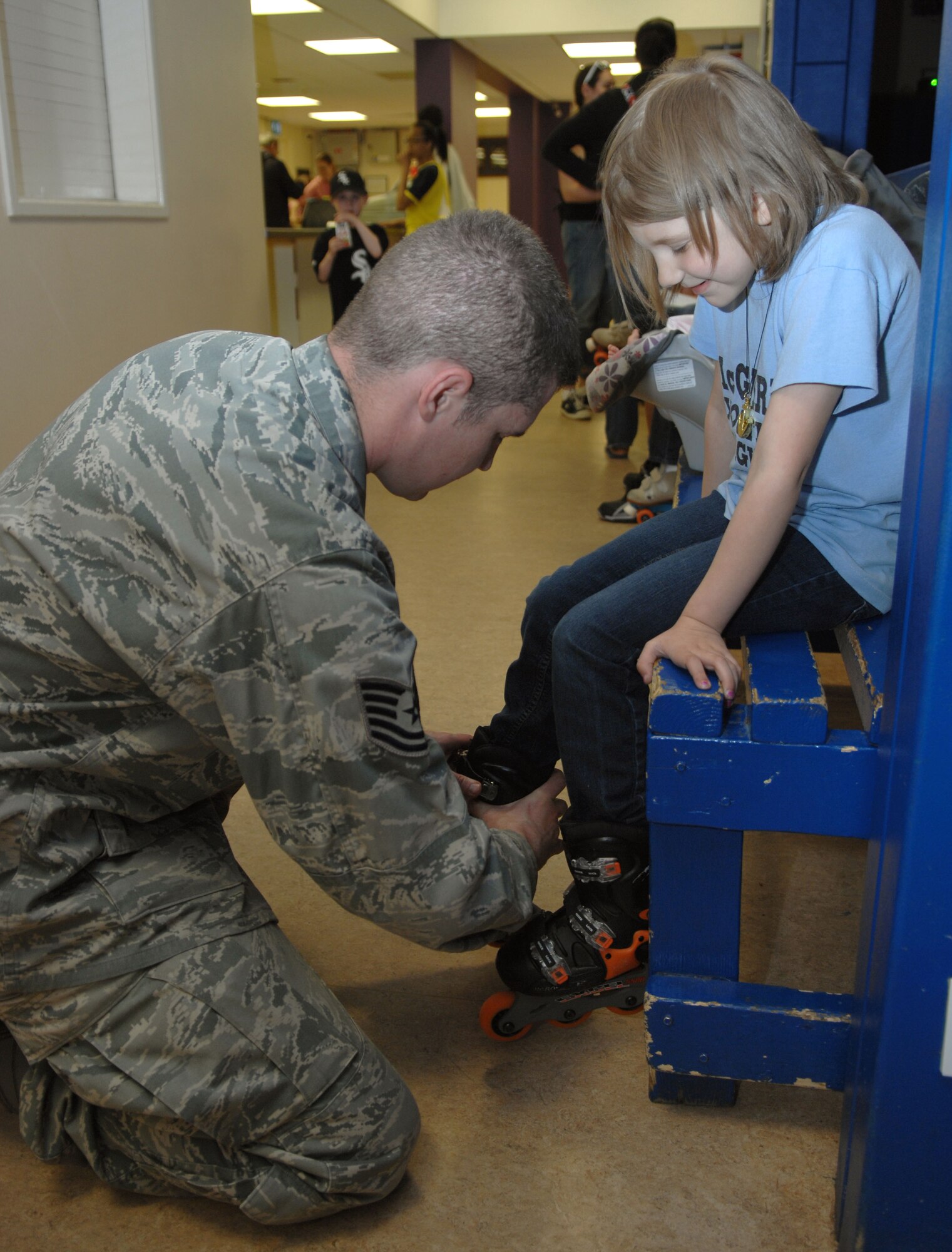 From left, Tech. Sgt. Keith Skulimoski, 100th Civil Engineer Squadron prime base engineer emergency force manager from Pemberton Township, N.J., helps his daughter, Elora, 7, put on roller skates June 17, 2013, during a skate and craft night at the skate rink on RAF Lakenheath, England. The 100th Force Support Squadron Exceptional Family Member Program hosted the event, allowing families to get out and have some fun together. (U.S. Air Force photo by Airman 1st Class Dillon Johnston/Released)