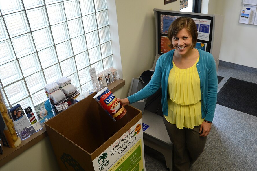 Janine Reinholtz, Health and Wellness Center dietician, places a box of oatmeal into a Harvest Hope food drive bin at Shaw Air Force Base, S.C., June 17, 2013.  Harvest Hope is collecting food from 20 counties in South Carolina to give to the less fortunate. Harvest Hope has food banks in Florence, as well as locations in Columbia and Lexington, S.C., and Greater Greenville, N.C. (U.S. Air Force photo by Airman 1st Class Nicole Sikorski/Released) 