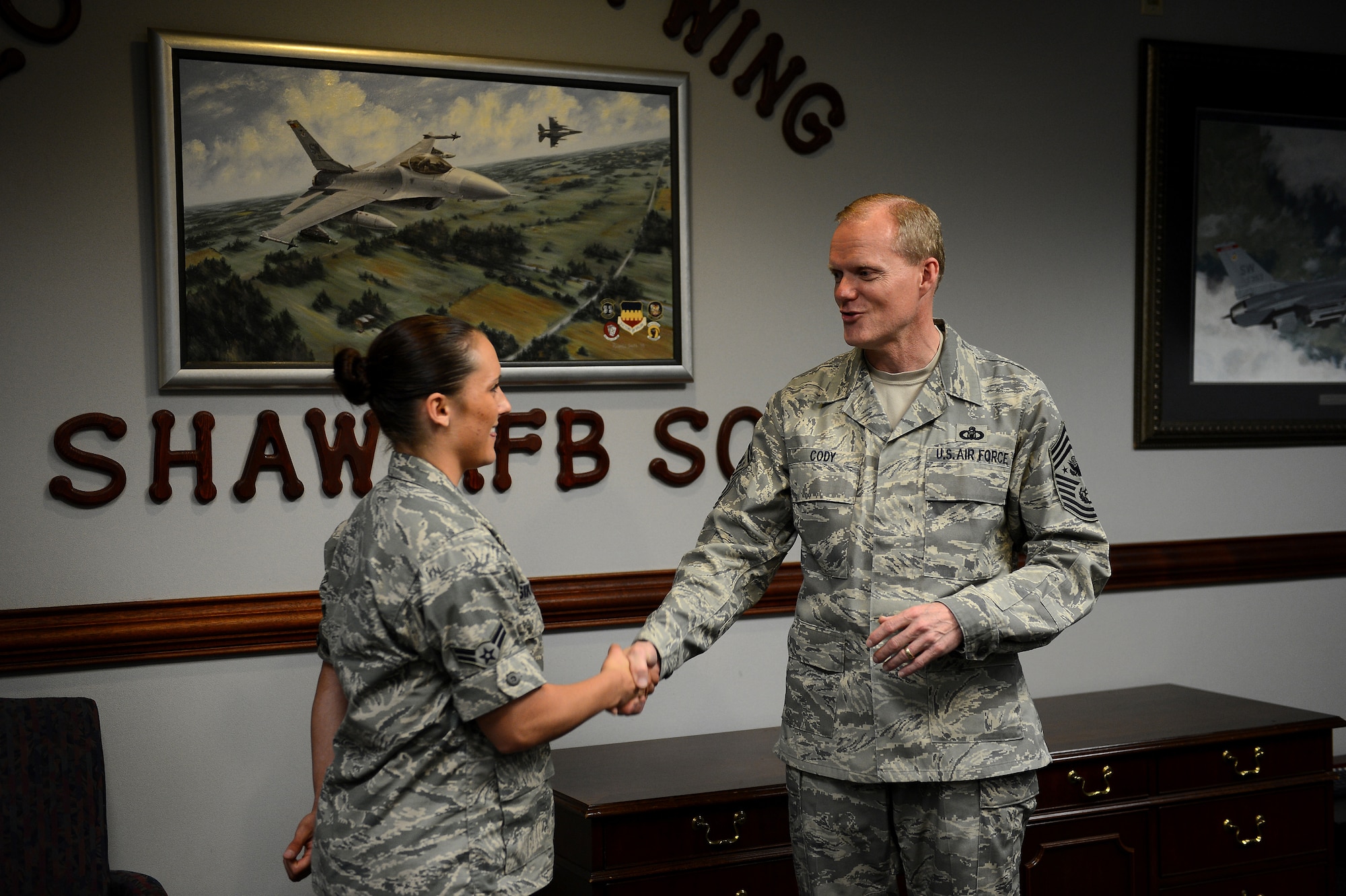 Chief Master Sgt. of the Air Force James Cody coins Airman 1st Class Nicole Sikorski, 20th Fighter Wing, wing staff agencies at Shaw Air Force Base, S.C., June 17, 2013.  Sikorski was recognized for professionalism and outstanding public affairs support to the 20th Fighter Wing and Air Combat Command. (U.S. Air Force photos by Airman 1st Class Krystal M. Jeffers/Released)