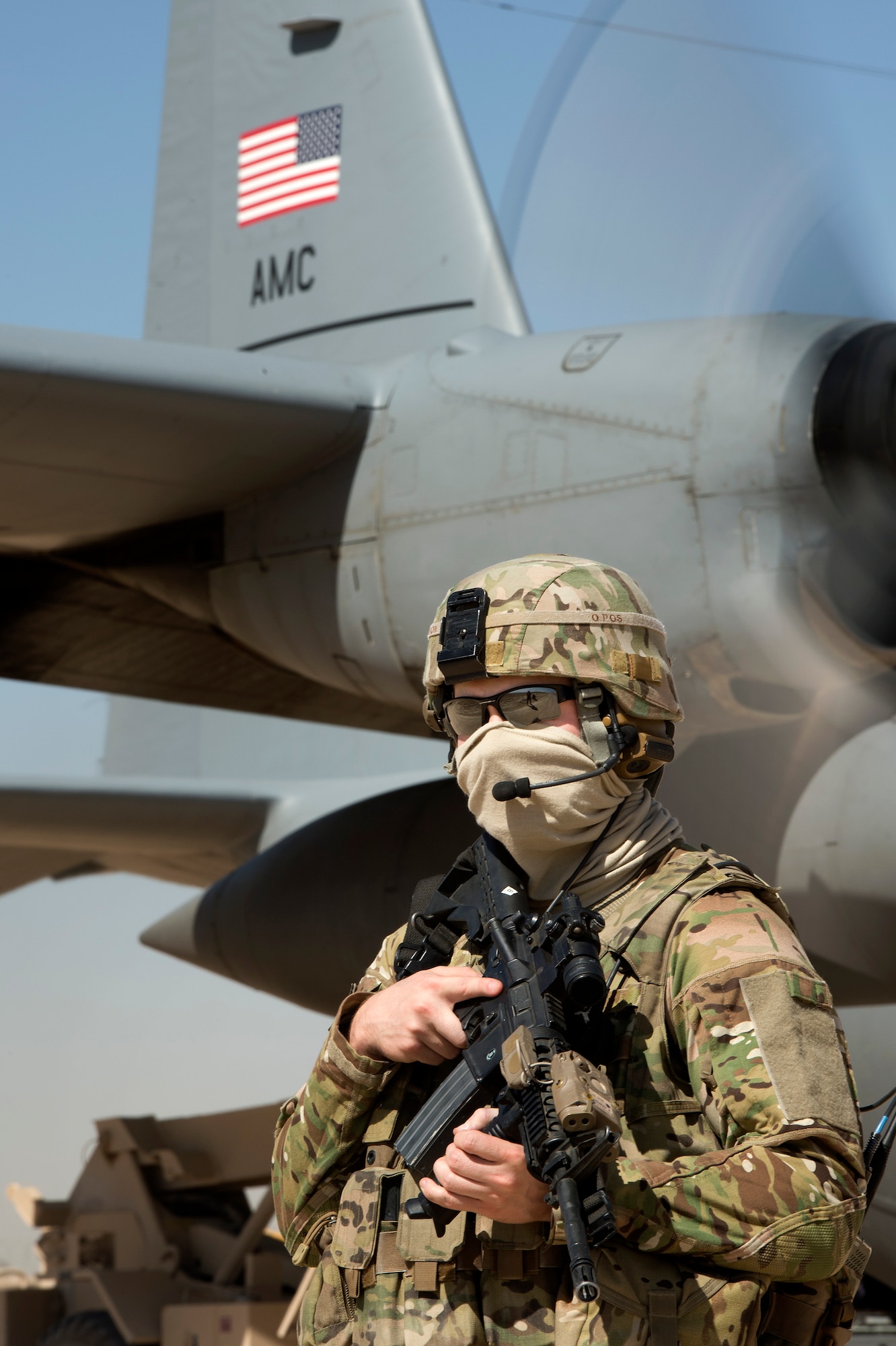 Senior Airman Michael Bullen, 455th Expeditionary Security Forces Squadron Fly-Away Security Team member, scans a remote airfield for potential threats in Qalat, Afghanistan, while a C-130 Hercules from the 774th Expeditionary Airlift Squadron transfers equipment and personnel June 10, 2013. FAST members are required to fly on specific missions when a location requires an extra measure of security to ensure the aircraft and crew are protected from hostile fire or on-board security breaches. Bullen hails from Minot, N.D., and is deployed from Hector Air Field, North Dakota Air National Guard. (USAF Photo/Master Sgt. Ben Bloker)