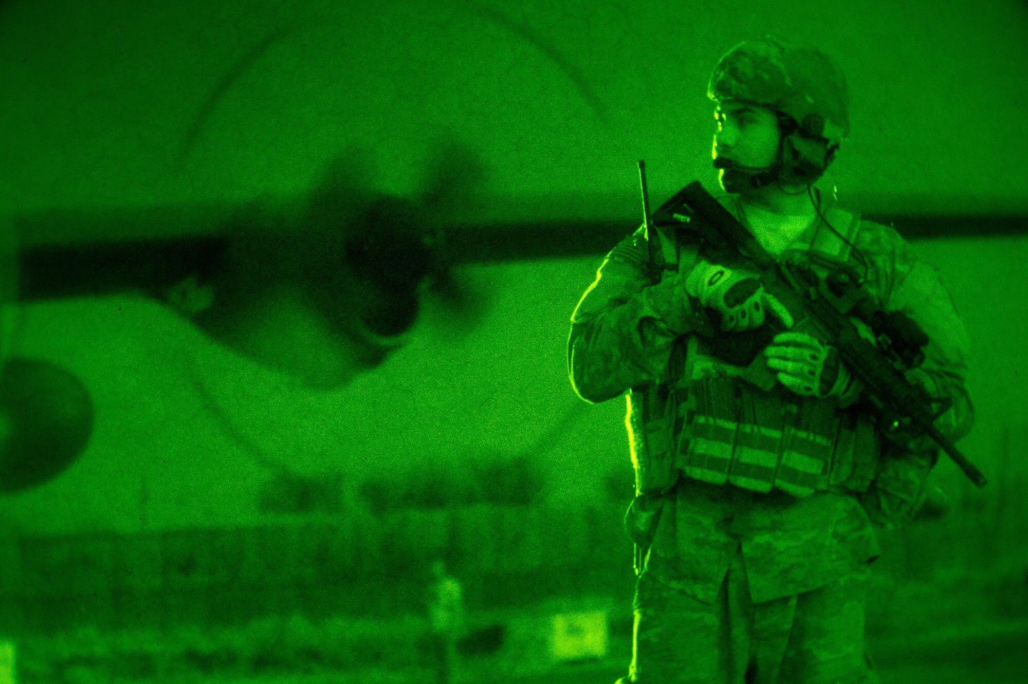 As night sets in, Airman 1st Class Everardo Torres, 455th Expeditionary Security Forces Squadron Fly-Away Security Team member, scans an airfield for potential threats in Jalalabad, Afghanistan, while a C-130 Hercules from the 774th Expeditionary Airlift Squadron transfers equipment and personnel June 11, 2013. FAST members are required to fly on specific missions when a location requires an extra measure of security to ensure the aircraft and crew are protected from hostile fire or on-board security breaches. Torres hails from Dallas, Texas, and is deployed from Davis-Monthan, Ariz. (USAF Photo/Master Sgt. Ben Bloker)