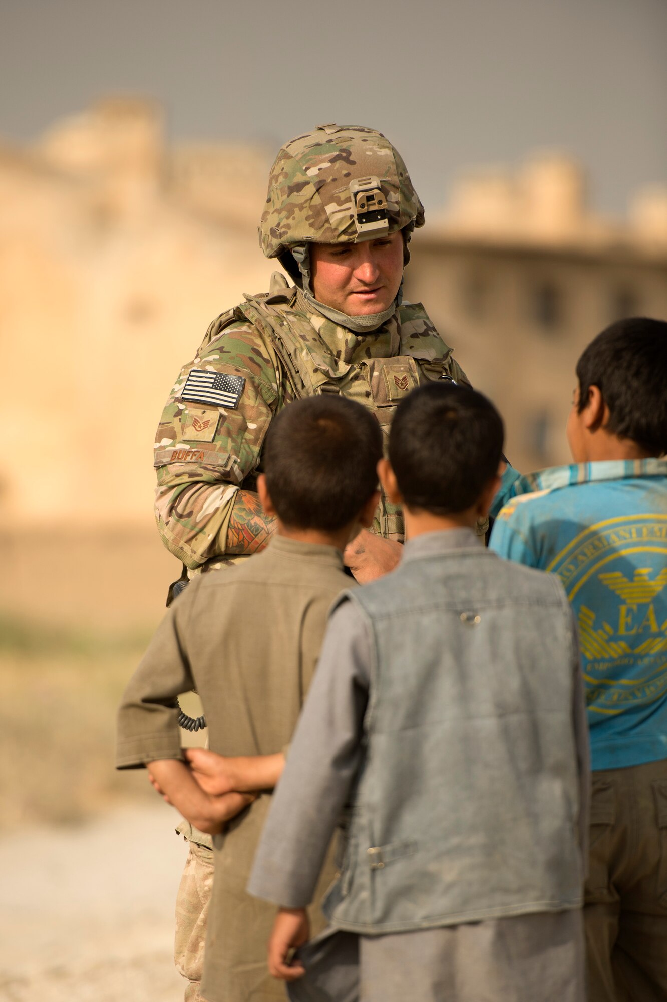 Staff Sgt. Brandon Buffa, 577th Expeditionary Prime Base Engineer Emergency Force Squadron, talks with local Afghan youth in the town of Payan Janqadam near Bagram Air Field, Afghanistan, June 13, 2013. The 455th Expeditionary Security Forces Group airmen teamed up with 577th Expeditionary Prime BEEF pavement and heavy equipment “Dirt Boys” to rebuild a road connecting Payan Janqadam with Saka. Buffa hails from St. Louis, Mo., and is deployed from Holloman Air Force Base, N.M. (USAF Photo/Master Sgt. Ben Bloker)