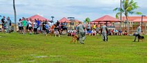 Service members watch as a crowd volunteer participates in a military working demonstration June 14, 2013, during a Dorm Dweller and Deployer Appreciation Day event on Andersen Air Force Base, Guam. The day’s festivities also included a flag football tournament, open use of the base pool, a giant slip and slide, corn-hole toss, ladder golf, hula dance performances and a first sergeant and commander dunk tank. (U.S. Air Force photo by Airman 1st Class Marianique Santos/Released)