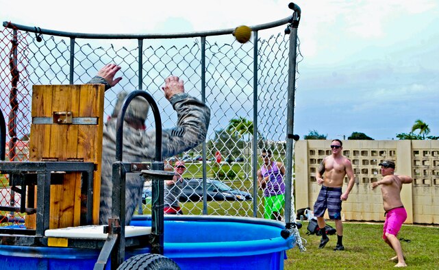 Master Sgt. KC Smith, 36th Contingency Response Group first sergeant, falls into the dunk tank June 14, 2013, on Andersen Air Force Base, Guam, as multiple Airmen hit the target during a Dorm Dweller and Deployer Appreciation day event. The 36th Wing Chapel-funded event was hosted by the 36th Maintenance Group, who organized island-themed performances and games. (U.S. Air Force photo by Airman 1st Class Marianique Santos/Released)