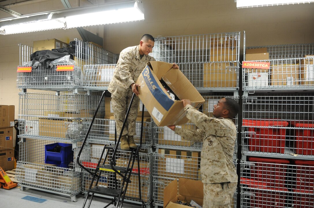 Cpl. Michael Ramirez hands a box down to Cpl. Angelo Powers in the Security Battalion warehouse. The Certified Logistics Technician pilot program aims to help supply Marines like Ramirez and Powers, as well as other logistics Marines, get civilian certification through the Manufacturing Skills Standard Council. 