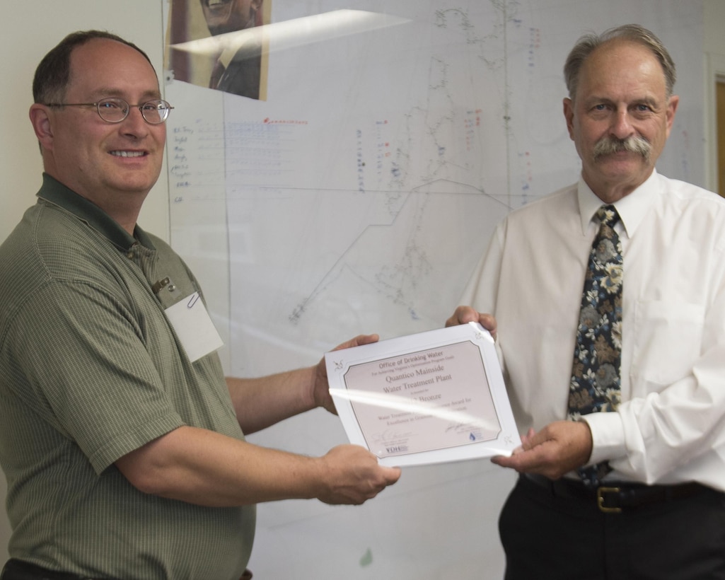 Robert Edelman, head of the Culpeper field office of the Virginia Department of Health’s Office of Drinking Water, left, presents a 2012 excellence award to Danny Gilley, head of Quantico’s Mainside Water Treatment Plant on May 29, 2013. 