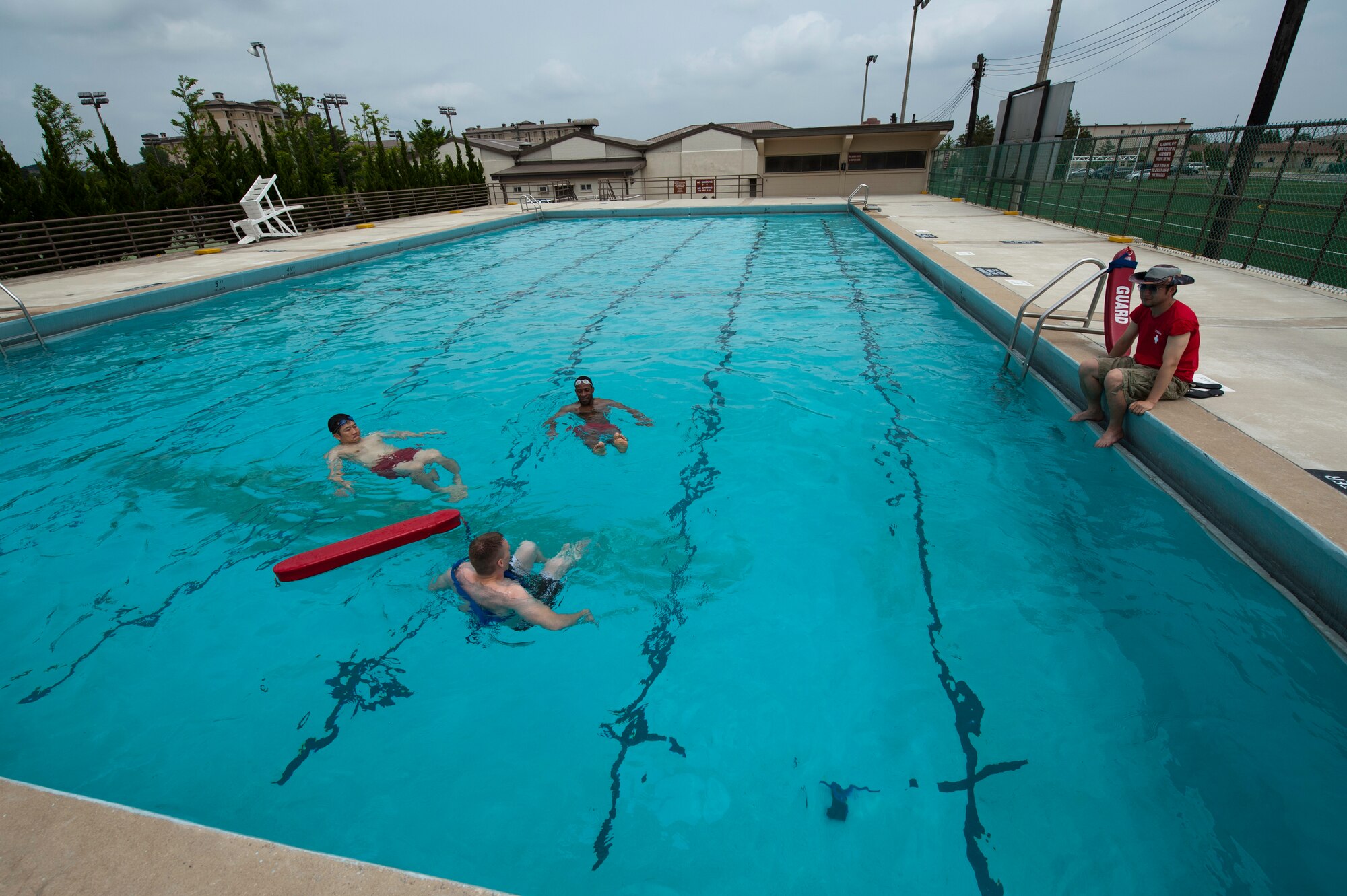 Kyung Hoon, contractor lifeguard, left, Staff Sgt. Devon Smith, 8th Civil Engineer Squadron company fire officer, center, perform pool lifeguard floating drills as Hokun Sim, 8th Force Support Squadron outdoor recreation aquatics manger, right, ensures their proficiency at Kunsan Air Base, Republic of Korea, June 17, 2013. The outdoor pool is scheduled to open for this summer as soon as the lifeguards are fully trained. (U.S. Air Force photo by Senior Airman Armando A. Schwier-Morales) 