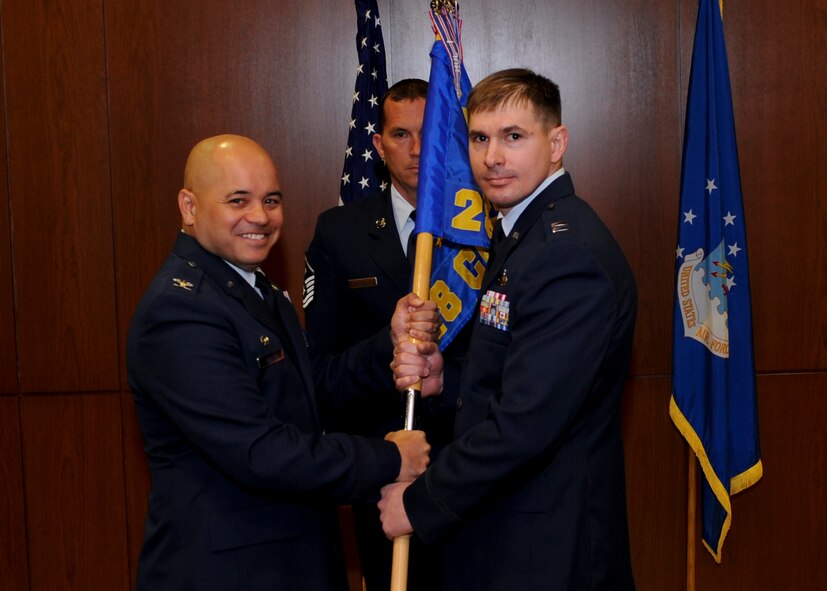 Col. Thomas Goulter Jr. (left), 28th Mission Support Group commander, presents the guidon of the 28th Contracting Squadron to the new 28th CONS commander, Capt. Steven Vanden Bos, during a change of command ceremony at Ellsworth Air Force Base, S.D., June 18, 2013. Vanden Bos, who comes to Ellsworth from Peterson AFB, Colo., will command the 28th CONS which provides premier business advice to all military organizations on Ellsworth.  (U.S. Air Force photo illustration by Airman 1st Class Anania Tekurio/Released)