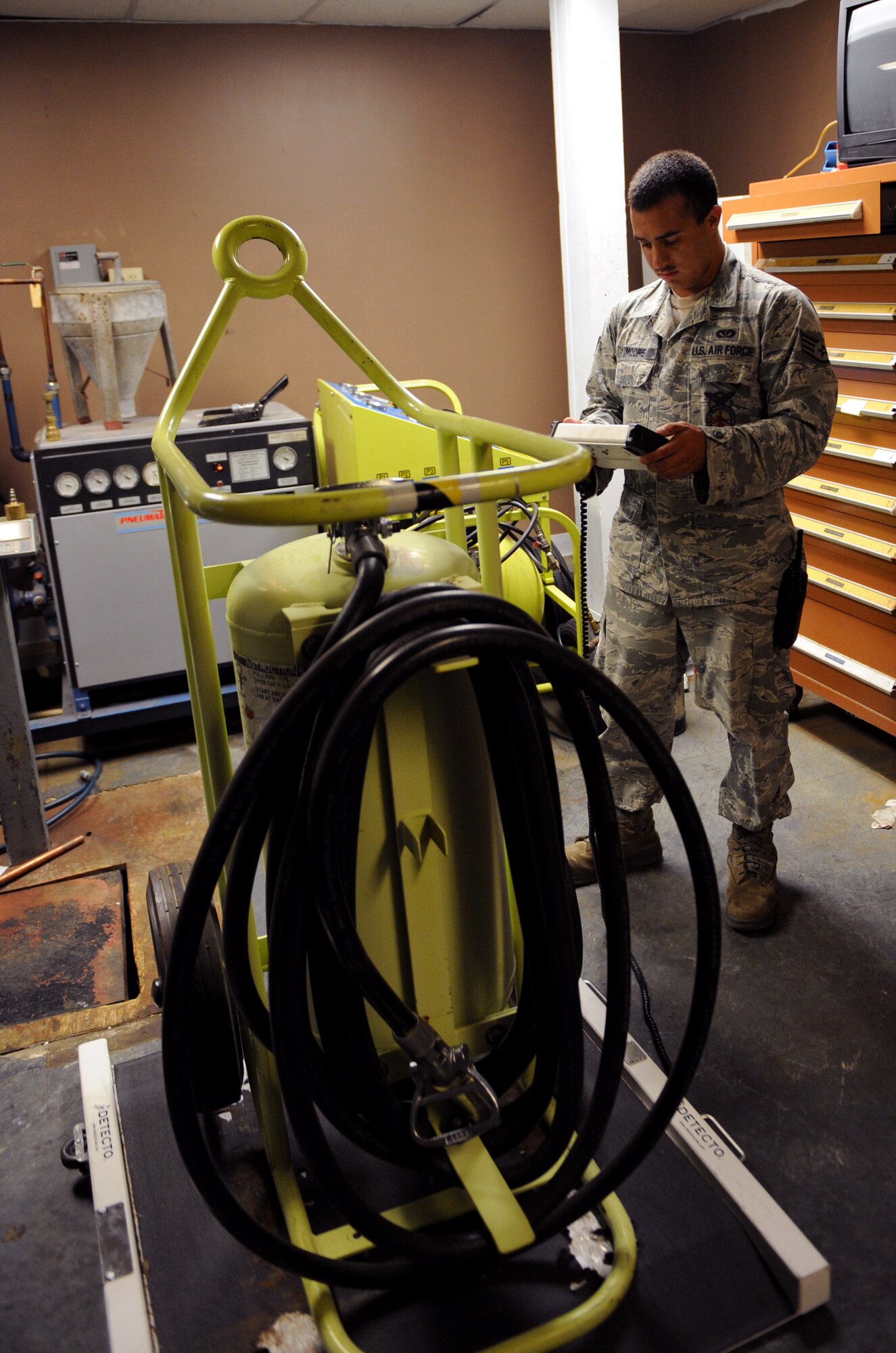 Staff Sgt. Frank Moore, 2nd Civil Engineer Squadron firefighter, views the weight of a flightline fire extinguisher on Barksdale Air Force Base, La., June 19, 2013. When fully serviced, flightline fire extinguishers must be within five pounds of 310 pounds. (U.S. Air Force photo/Airman 1st Class Benjamin Gonsier)
