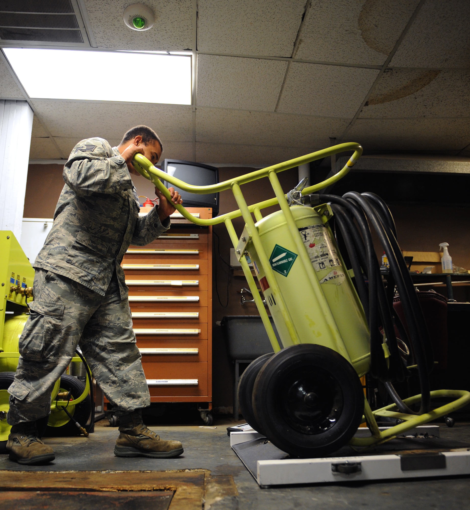 Staff Sgt. Frank Moore, 2nd Civil Engineer Squadron firefighter, places a flightline fire extinguisher on a weighing machine on Barksdale Air Force Base, La., June 19, 2013. When fully serviced, flightline fire extinguishers must be within five pounds of 310 pounds. (U.S. Air Force photo/Airman 1st Class Benjamin Gonsier)
