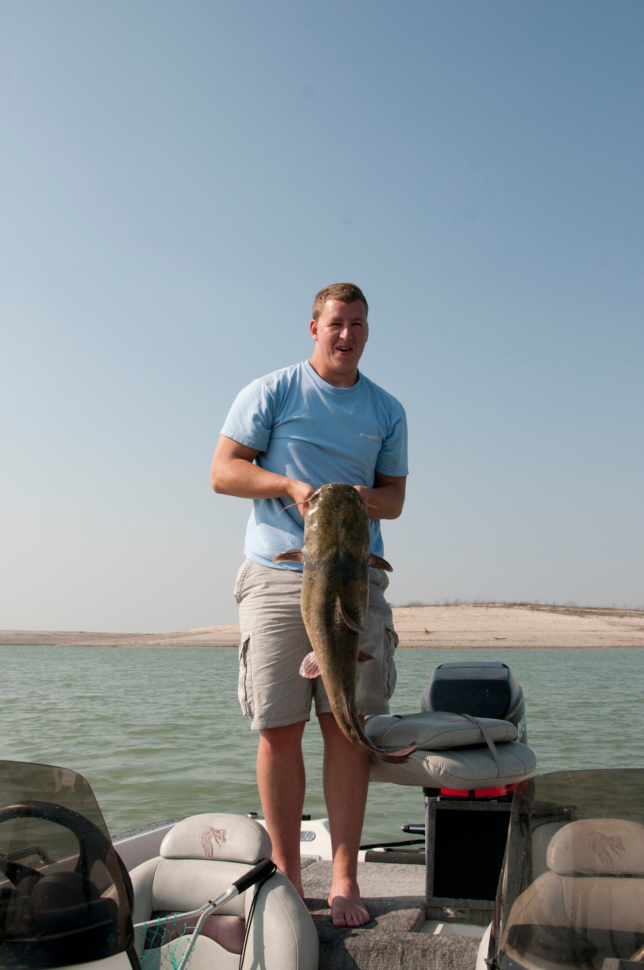 Senior Airman George Trosper, 47th Operations Support Squadron weather forecaster, poses for a picture with a catfish he caught on Lake Amistad near Del Rio, Texas, May 19, 2013. The fish fought Trosper for five to 10 minutes before Trosper could use a net to pull it in. (U.S. Air Force photo/Airman 1st Class Jimmie D. Pike)