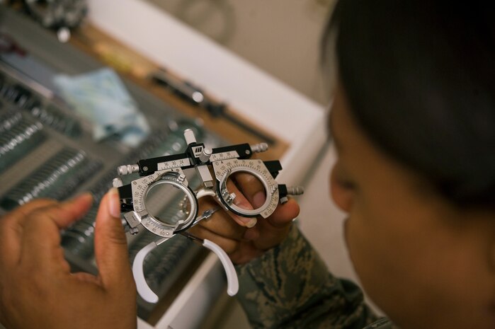 Maj. Syreeta Lawrence, 628th Medical Group optometrist, adjusts a set of trial frames for a patient June 18, 2013, at Joint Base Charleston – Air Base, S.C. Optometrists examine, diagnose, treat and manage diseases, injuries and disorders of the visual system, the eye and associated structures, as well as identify related systemic conditions affecting the eye. (U.S. Air Force photo/ Senior Airman George Goslin)