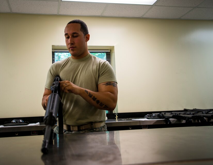 Staff Sgt. Edgardo Oliveras, 628th Security Forces Squadron Combat Arms Training and Maintenance instructor, inspects the charging handle on an M-16 rifle June 13, 2013, at Joint Base Charleston – Air Base, S.C. The CATAM instructors go through each part of the gun looking for cracks, corrosion or general damage to the weapons. (U.S. Air Force photo/ Senior Airman Dennis Sloan)