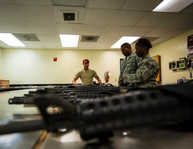 Staff Sgt. Adam Thompson, 628th Security Forces Squadron Combat Arms Training and Maintenance instructor, lines M-16 rifles on an inspection table at CATAM June 13, 2013, at Joint Base Charleston, S.C. The CATAM instructors thoroughly inspect each weapon, looking for cracks, corrosion or general damage to the weapons. (U.S. Air Force photo/ Senior Airman Dennis Sloan)