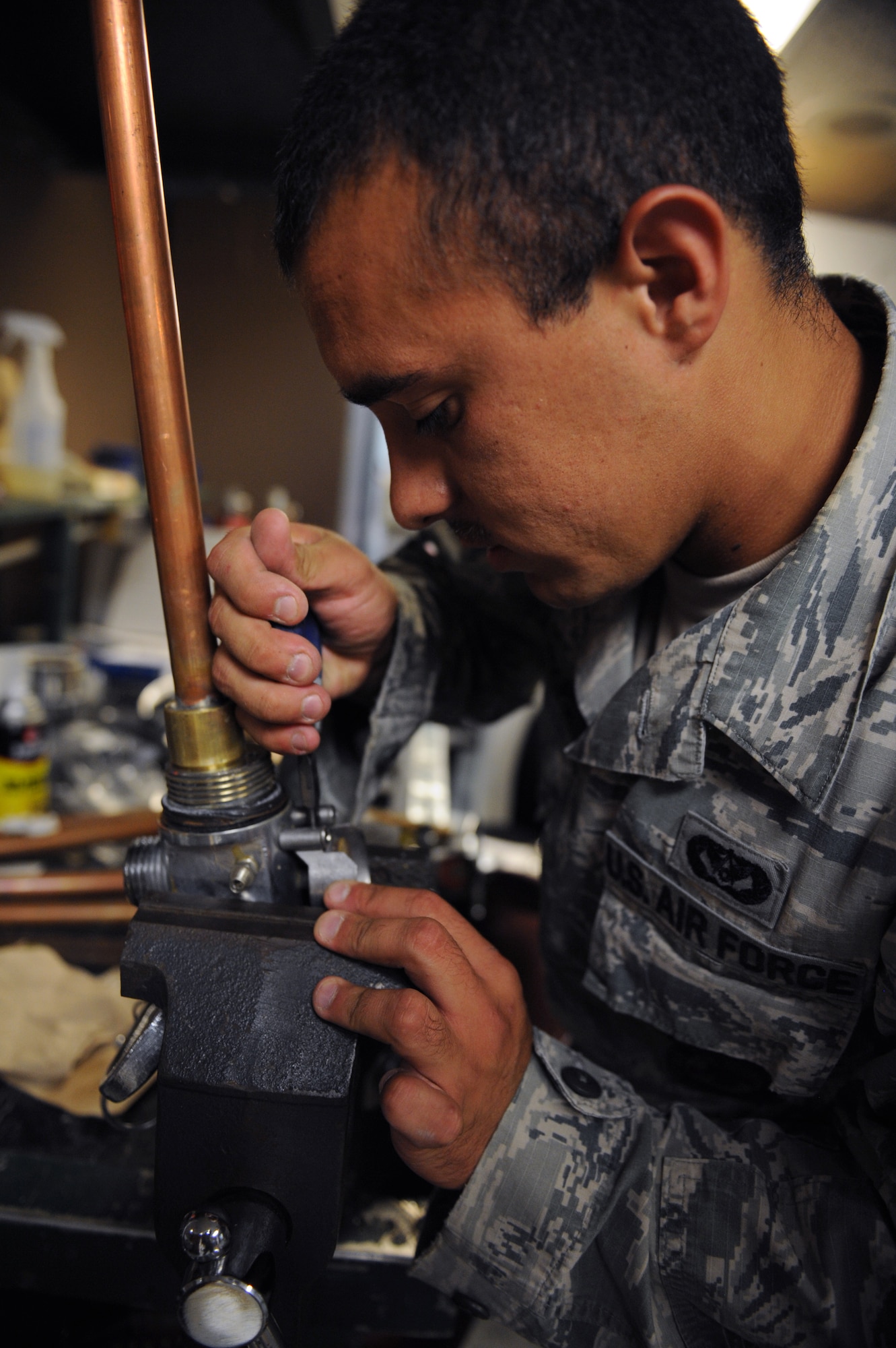 Staff Sgt. Frank Moore, 2nd Civil Engineer Squadron firefighter, removes a gauge from a cylinder valve assembly on Barksdale Air Force Base, La., June 19, 2013. Gauges need to be replaced every so often to ensure the flightline fire extinguisher works properly and is giving the right readings. (U.S. Air Force photo/Airman 1st Class Benjamin Gonsier)