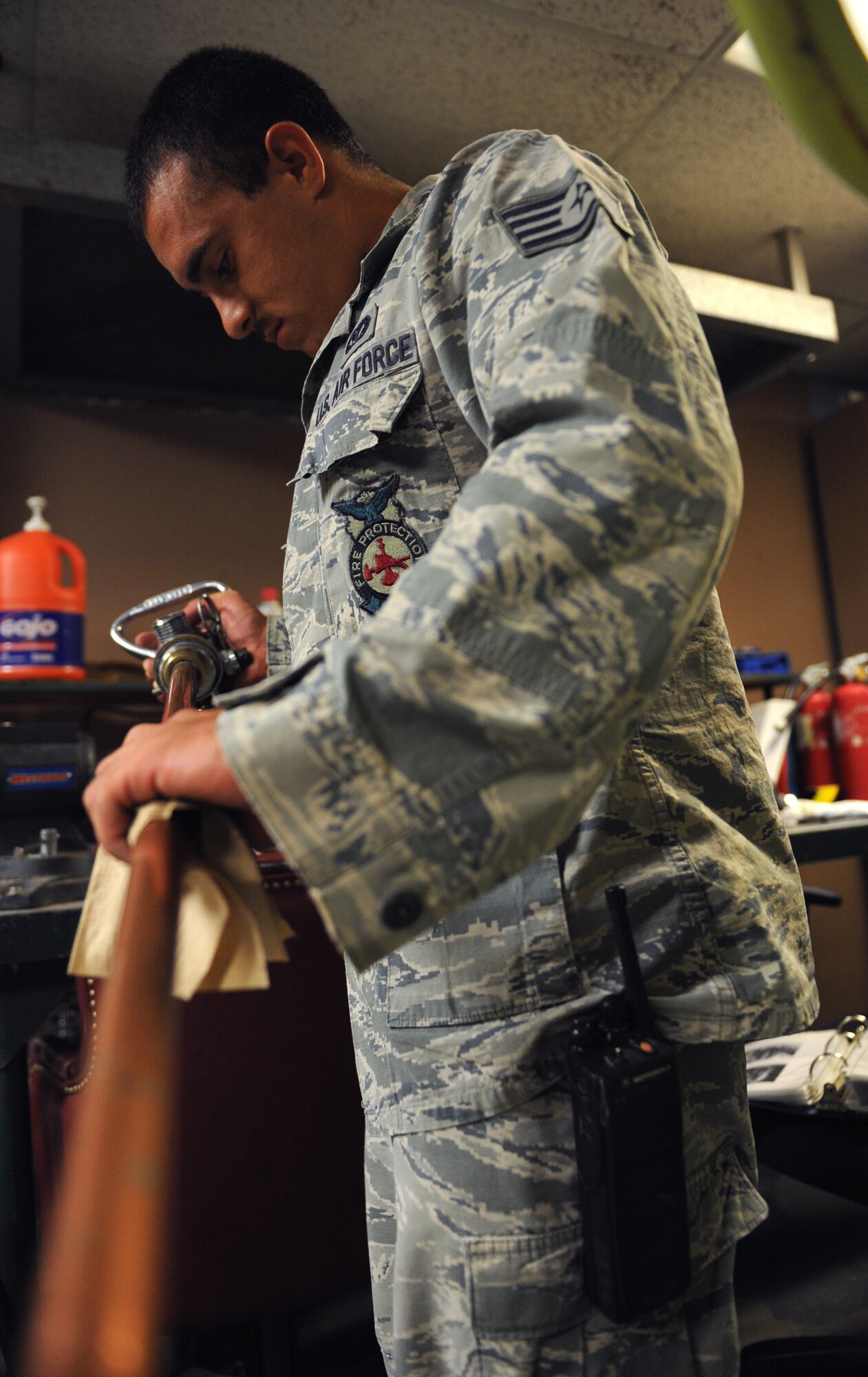 Staff Sgt. Frank Moore, 2nd Civil Engineer Squadron firefighter, cleans a cylinder valve assembly on Barksdale Air Force Base, La., June 19, 2013. Barksdale firefighters maintain the flightline fire extinguishers to ensure mission readiness in case of a fire. (U.S. Air Force photo/Airman 1st Class Benjamin Gonsier)
