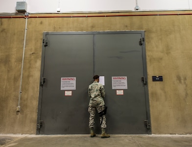 Staff Sgt. Theresa Davis, 628th Logistics Readiness Squadron Individual Protective Equipment technician, unlocks the LRS vault to transfer M-16 rifles to Airmen at the 628th Security Forces Squadron Combat Arms Training for an inspection June 13, 2013, at Joint Base Charleston – Air Base, S.C. Davis is armed with an M-9 pistol since she will be escorting the weapons to the CATAM building. (U.S. Air Force photo/ Senior Airman Dennis Sloan)