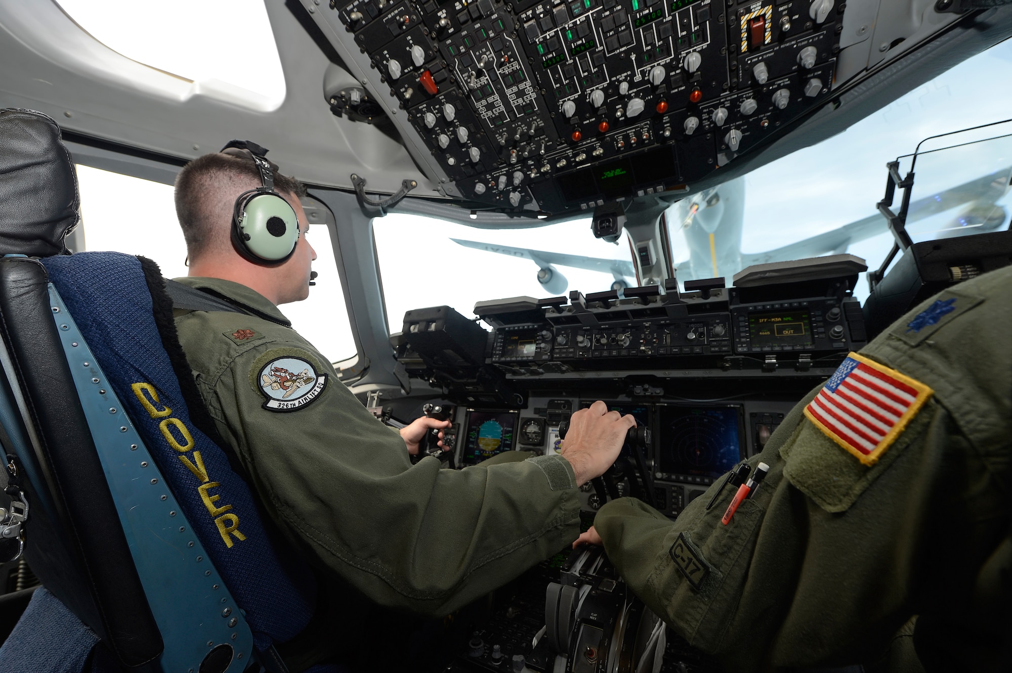 Maj. Rich Polehemus, of the 326th Airlift Squadron, 512th Airlift Wing, Air Force Reserve Command, carefully adjusts the throttles of a C-17A Globemaster III during an in-flight refueling from a KC-135R Stratotanker of the 171st Air Refueling Wing, Pennsylvania Air National Guard during a training mission from Dover Air Force Base, Del., on June 18, 2013. Lt. Col. Hugh Hamiliton's hand can also be seen on the throttles as a back-up and safety measure. Dover's fleet of C-5M and C-17A's are shared by active duty (436th) and reserve (512th) Wings. (U.S. Air Force photo/Greg L. Davis)