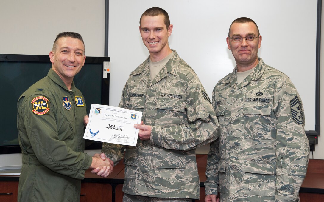 Staff Sgt. Joel R. Eschenbacher, 47th Force Support Squadron manpower analysis, poses with Col. Brian Hastings, 47th Flying Training Wing commander, and Chief Master Sgt. Gary Berry, 47th FTW command chief, after being presented the XLer of the week award here June 12, 2013. The XLer is a weekly award chosen by wing leadership and given to those who consistently make outstanding contributions to Laughlin and their unit. (U.S. Air Force photo/Airman 1st Class John D. Partlow)