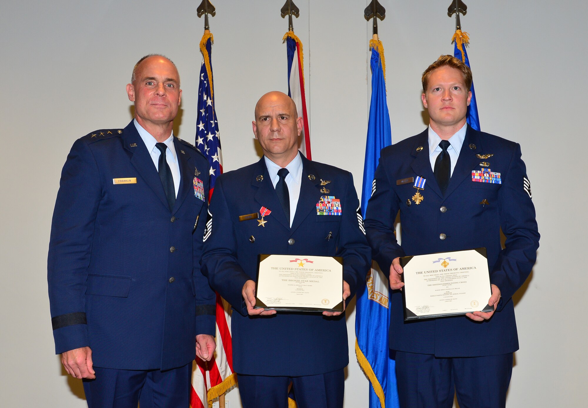 ROYAL AIR FORCE LAKENHEATH, England – Lt. Gen. Craig Franklin, 3rd Air Force and 17th Expeditionary Air Force commander, takes a photo with Bronze Star Medal with Valor recipient Master Sgt. Tracy Debbs, and Distinguished Flying Cross with Valor recipient Staff Sgt. Nicholas Miller, both 56th Rescue Squadron pararescuemen, after a medal presentation ceremony June 19, 2013. The pararescuemen received the honors for their life-saving actions conducted in Afghanistan Aug. 4, 2012. (U.S. Air Force photo by Staff Sgt. Stephanie Mancha)