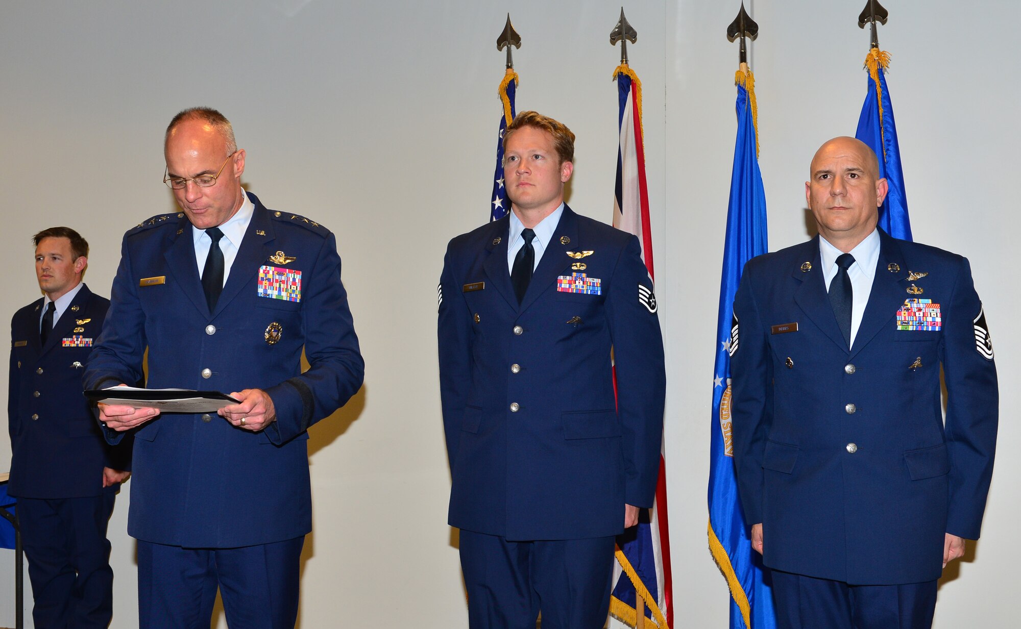 ROYAL AIR FORCE LAKENHEATH, England – Lt. Gen. Craig Franklin, 3rd Air Force and 17th Expeditionary Air Force commander, reads medal citations for Staff Sgt. Nicholas Miller and Master Sgt. Tracy Debbs , 56th Rescue Squadron pararescuemen, June 19, 2013. Miller was presented the Distinguished Flying Cross with Valor and Debbs was presented the Bronze Star Medal with Valor for saving critically-wounded coalition soldiers while taking enemy gunfire in Afghanistan on Aug. 4, 2012. (U.S. Air Force photo by Staff Sgt. Stephanie Mancha)