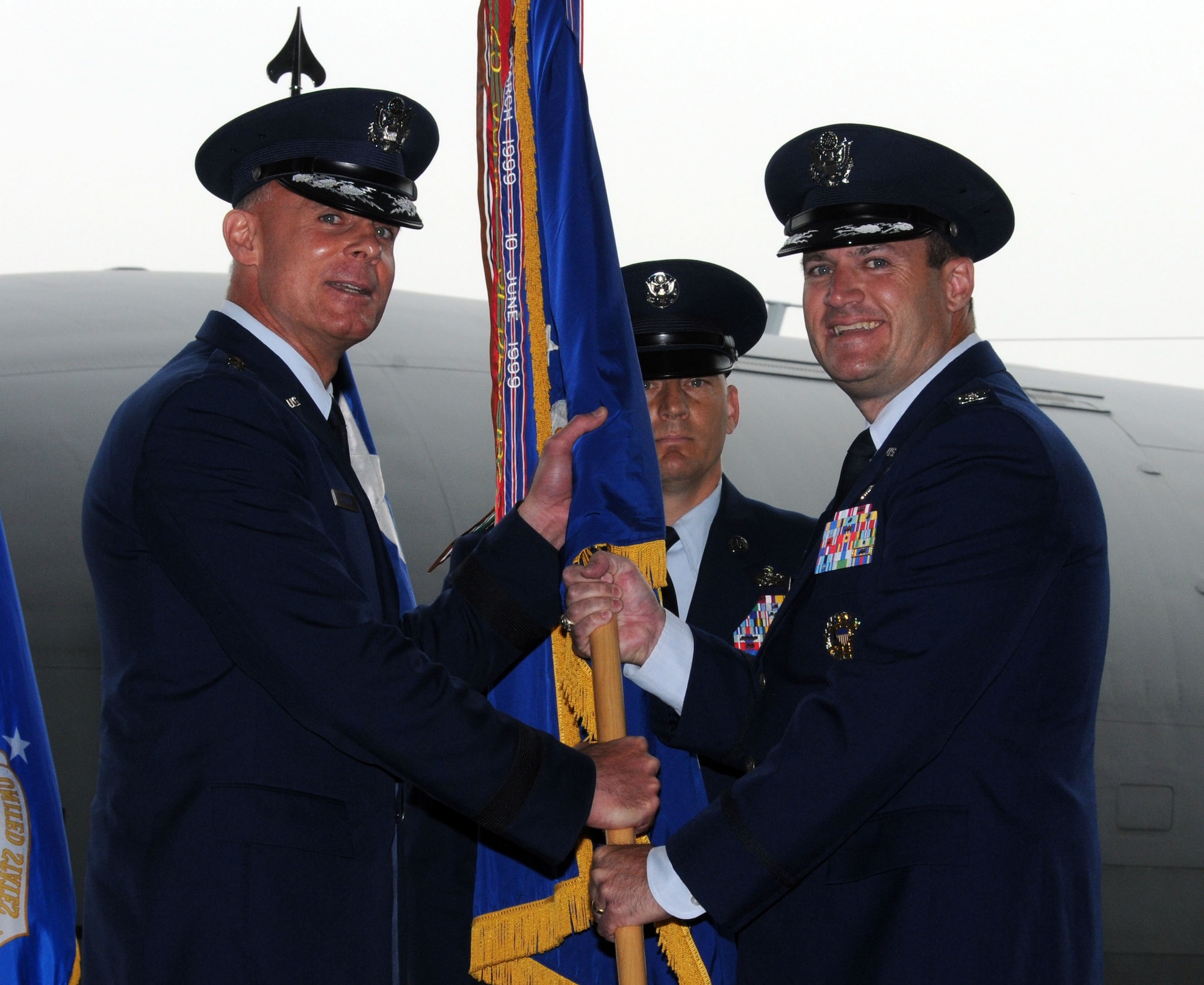From left, Lt. Gen. Craig Franklin, 3rd Air Force commander, Ramstein Air Base, Germany, gives command of the 100th Air Refueling Wing to Col. Kenneth T. Bibb Jr., 100th ARW commander, during the 100th ARW change of command ceremony June 19, 2013, on RAF Mildenhall, England. The passing of the unit guidon during a change of command ceremony is a symbolic representation of passing authority to the incoming commander for all to see.  (U.S. Air Force photo by Staff Sgt. Tabitha M. Lee/Released)