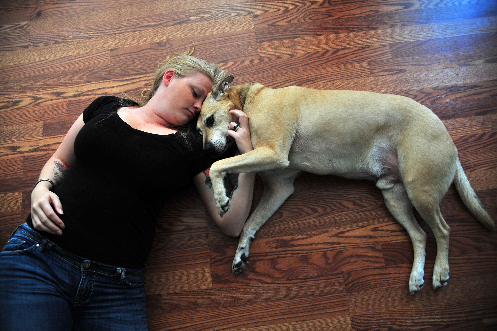 U.S. Air Force Staff Sgt. Kimberly Pate, 4th Civil Engineer Squadron explosive ordnance disposal (EOD) NCO in-charge of operations, relaxes with her dog, Art, at her home in Kinston, N.C., June 12, 2013. Pate and Art are each other’s biggest supporters since her husband died supporting combat operations in Afghanistan in 2011. (U.S. Air Force photo by Airman 1st Class Aubrey White/Released)