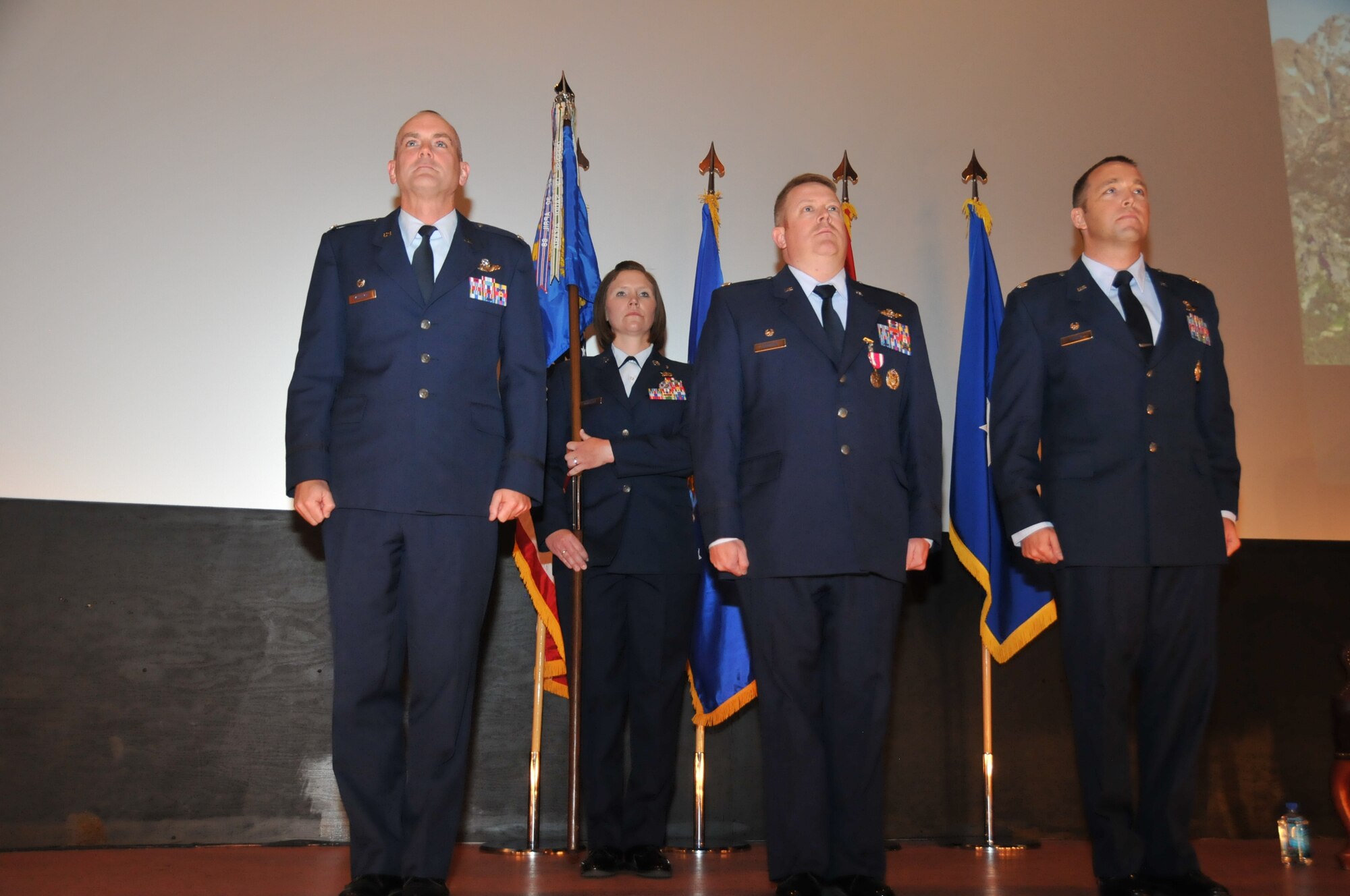 Col. Andrew McIntyre, 19th Operations Group commander, Lt. Col. Rodney Simpson, outgoing 30th Airlift Squadron commander and Lt. Col. Blair Kaiser, incoming 30 AS commander, prepare for a change of command at the F.E. Warren Air Force Base theatre, Cheyenne, Wyo., June 1, 2013. The 30th AS is an active associate flying squadron that partners with the 153rd Airlift Wing, Wyoming Air National Guard. (Air National Guard photo by Staff Sgt. John Galvin)