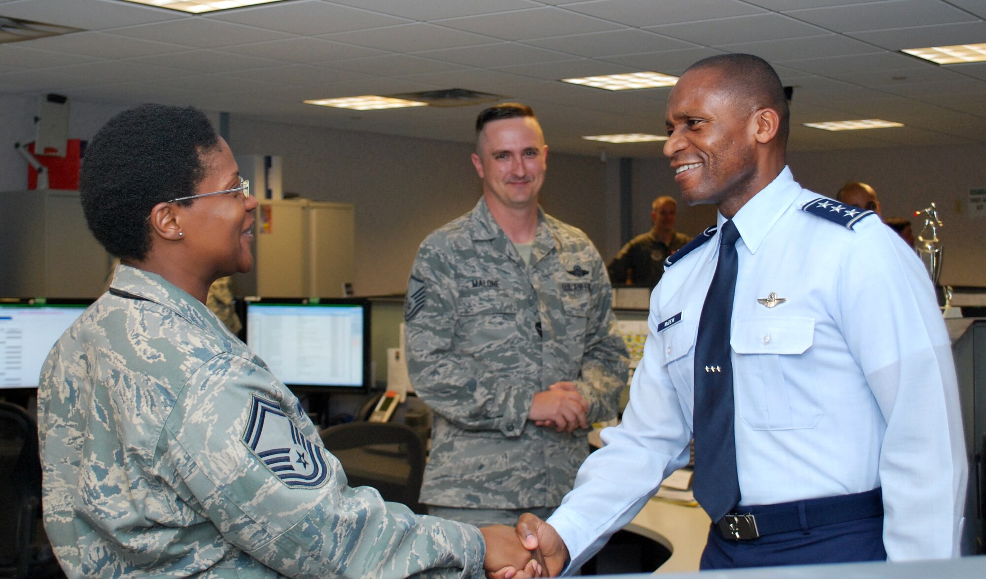 Lt. Gen. Darren McDew, 18th Air Force commander, shakes hands with Senior Master Sgt. Latricelean Wright, 618 Air and Space Operations Center’s Global Operations Division superintendent, during a visit to the AOC June 10, 2013. The Command and Control Directorate is a highly skilled command and control team exercising the AMC commander's authority and direction over AMC assigned and gained missions. It operates 24-hours-a-day, every day, providing first-class flight planning, diplomatic clearance, and integrated flight management services to aircrews from the moment a mission enters execution through mission completion. (U.S. Air Force photo by 1st Lt. Nicole White)