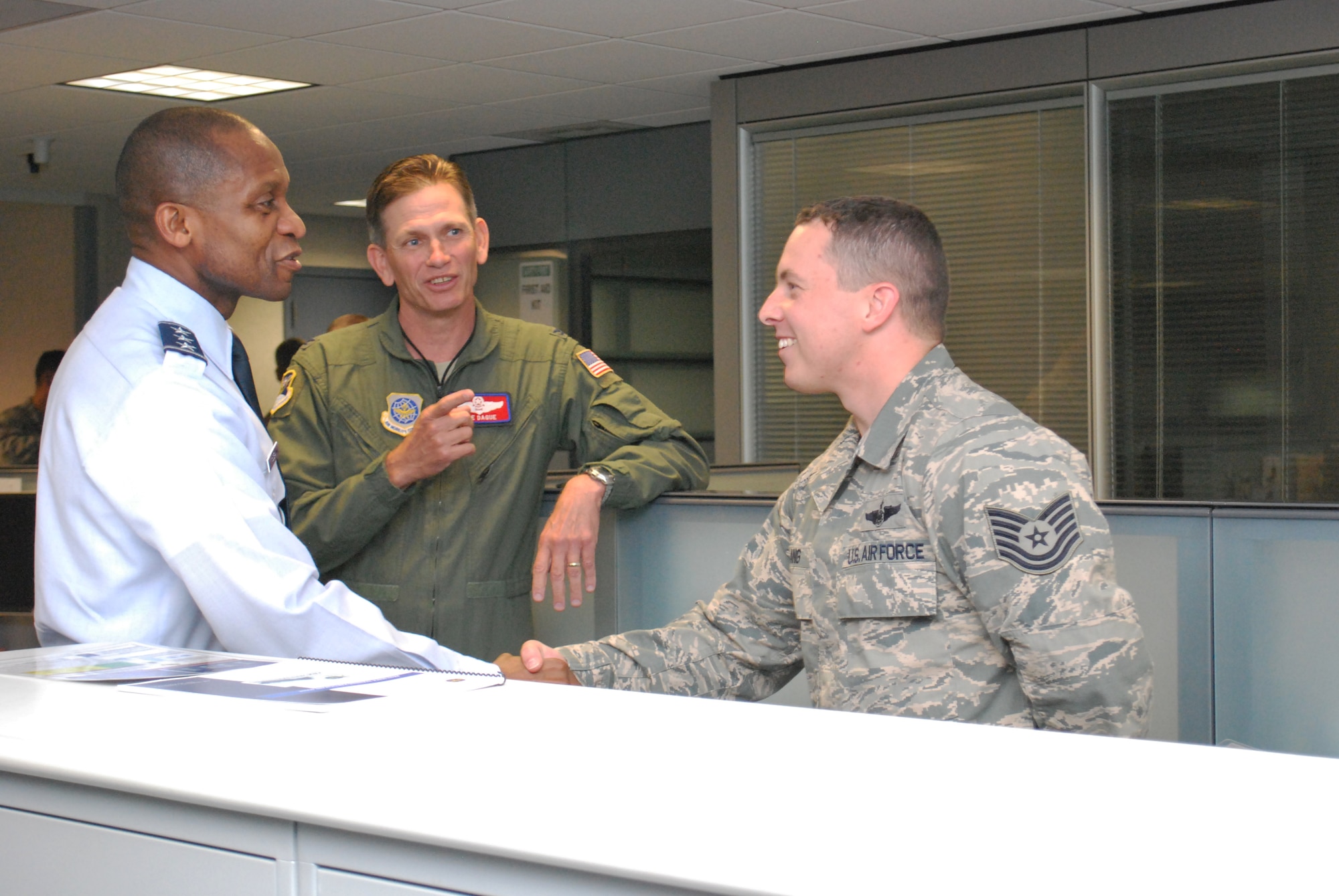 Lt. Gen. Darren McDew, 18th Air Force commander, coins Tech. Sgt. David Lang, a 618 Air and Space Operations Center mission director, June 10, 2013 during a visit to the AOC. The Current Operations Directorate where Lang works plans and monitors Air Force and commercial airlift and air refueling missions to meet Department of Defense and international customer requirements for movement of passengers, cargo, and air refueling in support of National Command Authority-directed classified programs, nuclear airlift, fighter and bomber deployment and employment, and distinguished visitor airlift. (U.S. Air Force photo by 1st Lt. Nicole White)