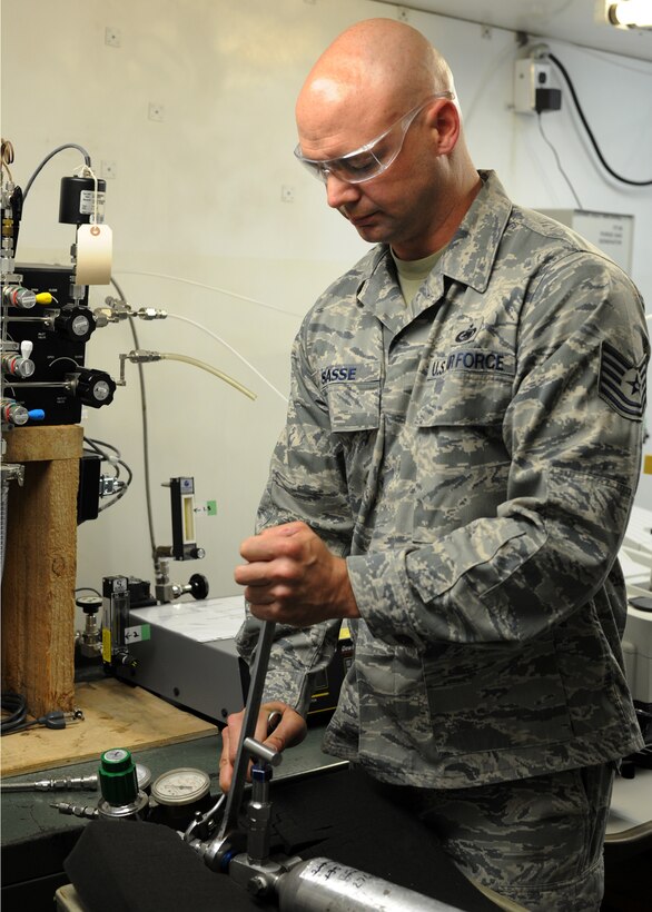 Tech. Sgt. Rocky Sasse tightens a canister to a device used to test gases for purity, odor, moisture and contamination in the 379th Expeditionary Logistics Readiness Squadron Air Force Petroleum Agency Laboratory in Southwest Asia, June 12, 2013. Sasse is the 379th ELRS AFPA NCO in charge of gases deployed from McConnell Air Force Base, Kan. (U.S. Air Force photo/Senior Airman Bahja J. Jones)