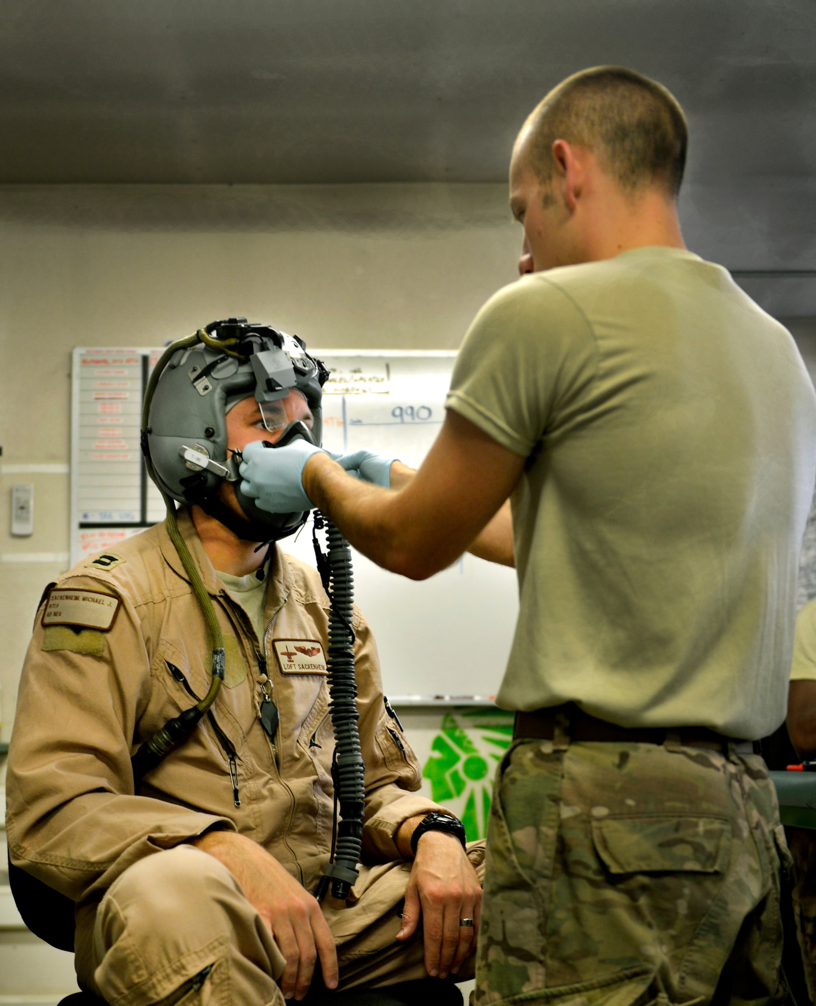Senior Airman Sean Crowell, 74th Expeditionary Fighter Squadron aircrew flight equipment technician, corrects the fit of Capt. Michael Sackenheim’s helmet and oxygen mask prior to a mission at Bagram Airfield, Afghanistan, June 17. If equipment does not fit properly the pilots display will be out of alignment, degrading the effectiveness of the A-10 pilot’s mission. Crowell is a native of Kalamazoo, Mich. (U.S. Air Force photo/ Staff Sgt.Stephenie Wade)