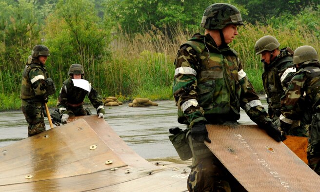 U.S. Air Force Airmen from 35th Civil Engineer Squadron airfield damage control flight work together to build a fiberglass mat to cover three craters created after a simulated missile attack during an Operational Readiness Exercise at Misawa Air Base, Japan, June 19, 2013. A mock runway area gives these Airmen the opportunity to practice repairing airfields in a realistic environment without actually digging holes on the active runway or taxiways. (U.S. Air Force photo by Airman 1st Class Kenna Jackson)