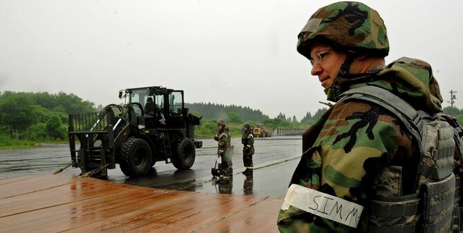 U.S. Air Force Col. Stephen Williams, 35th Fighter Wing commander, observes the 35th Civil Engineer Squadron airfield damage control flight as they repair a mock airfield during an Operational Readiness Exercise at Misawa Air Base, Japan, June 19, 2013. After an attack, CES Airmen had approximately four hours to repair simulated 50-foot craters and return the airfield to use. (U.S. Air Force photo by Airman 1st Class Kenna Jackson)