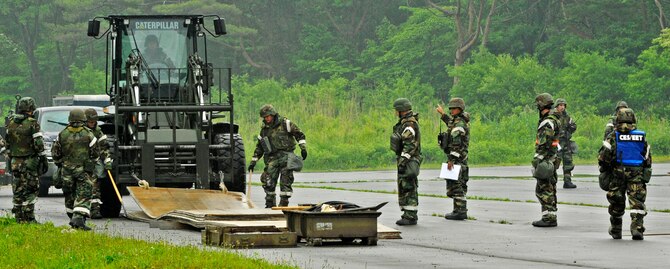 U.S. Air Force Airmen from the 35th Civil Engineer Squadron airfield damage control flight construct a 50-foot-long fiberglass matting surface after a simulated missile attack to the airfield during an Operational Readiness Exercise at Misawa Air Base, Japan, June 19, 2013. The 35th Fighter Wing's ORE tested Airmen's ability to operate in a high-alert contingency environment, making them better equipped to maintain base operational conditions during both peace and wartime. (U.S. Air Force photo by Airman 1st Class Kenna Jackson)