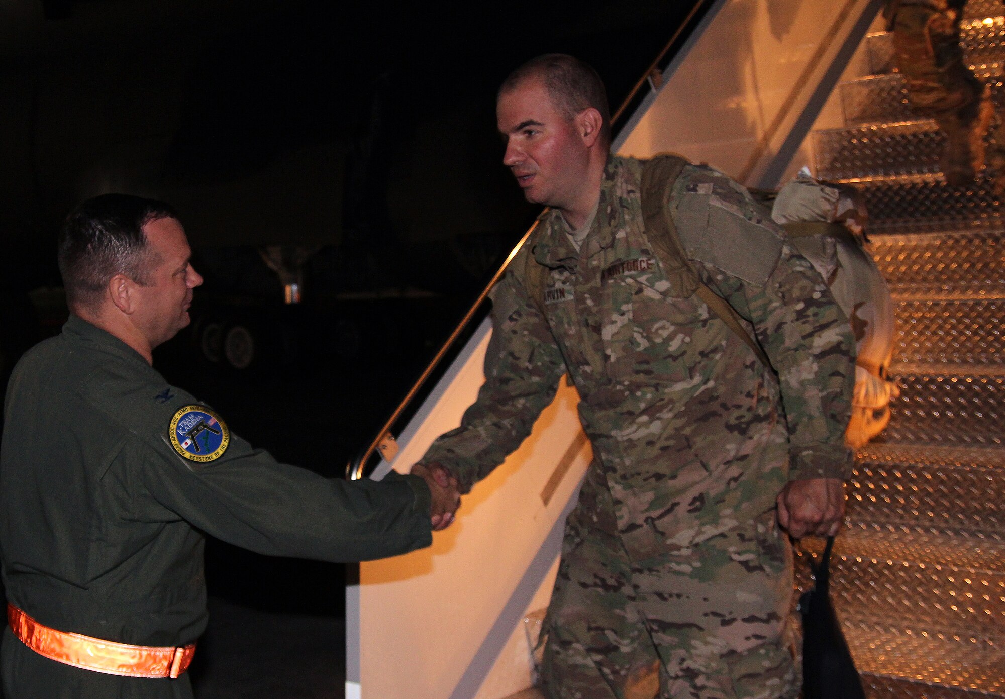 U.S. Air Force Col. Brian McDaniel, 18th Wing vice commander, welcomes home Staff Sgt. Patrick Garvin, 18th Operations Support Squadron aircrew flight equipment technician, shortly after a C-5 Galaxy landed on Kadena Air Base, Japan, June 18, 2013. More than 60 Kadena Airmen returned home after serving more than 100 days at Bagram Airfield, Afghanistan. (U.S. Air Force photo by Tech. Sgt. Jason Lake/Released)