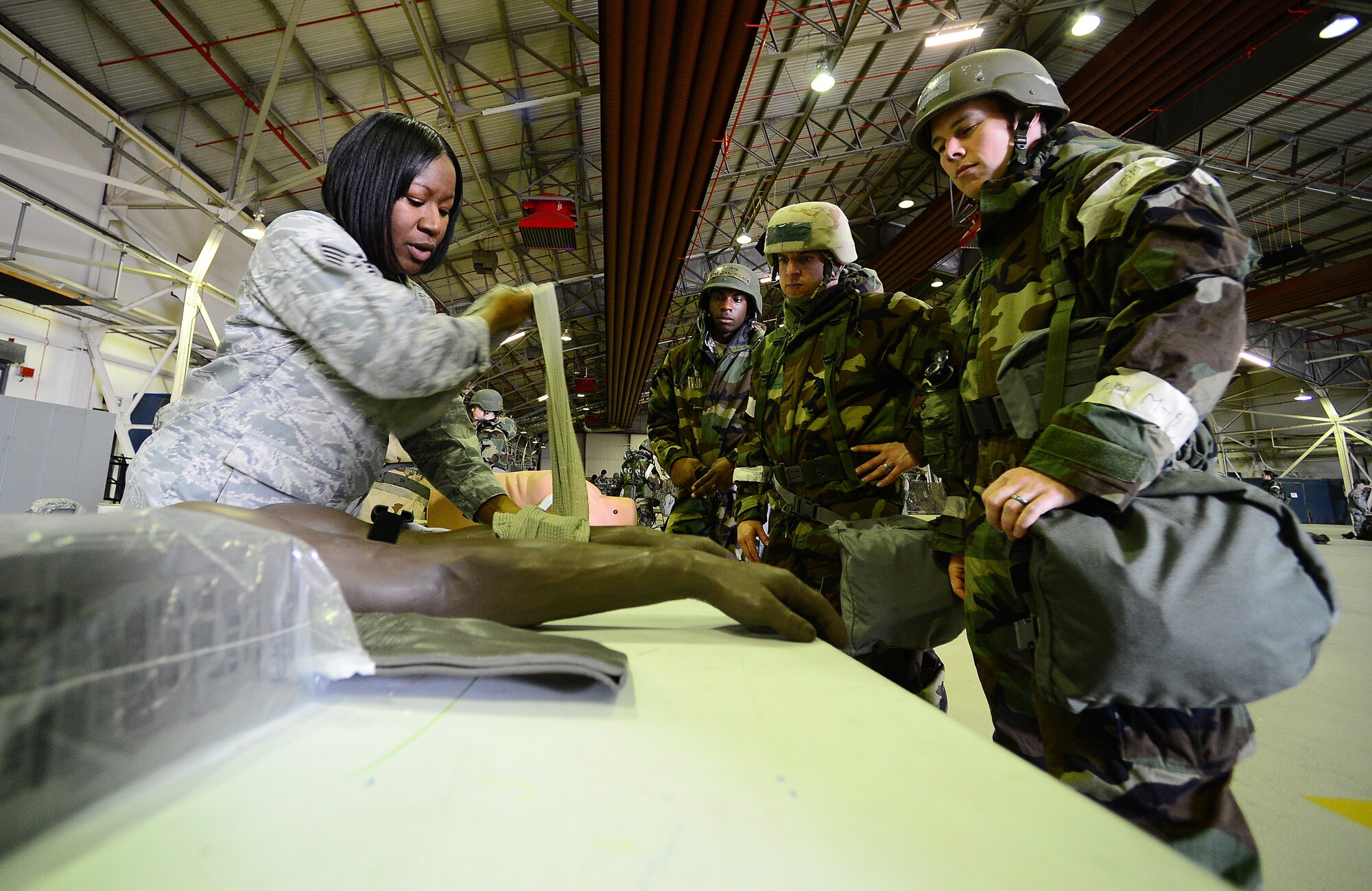 ROYAL AIR FORCE LAKENHEATH, England – Tech. Sgt. Tiffany Pittman, 48th Inpatient Care Squadron maternal child unit flight chief, shows Airmen how to wrap a bandage during the Ability to Survive and Operate Rodeo in Hangar 7 June 17, 2013. ATSO training provided Airmen readiness training in preparation for the Phase II exercise. (U.S. Air Force photo by Senior Airman Tiffany M. Grigg)