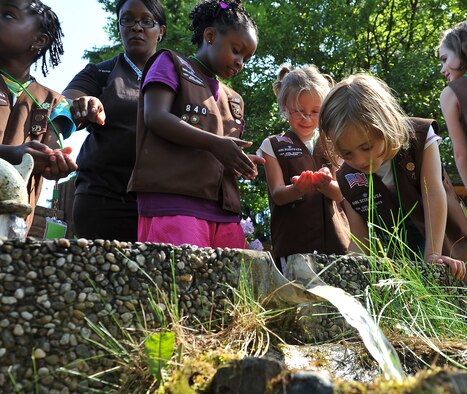 USA Girl Scouts Overseas play in the water during their field trip to the water treatment facility, June 13, 2013, Ramstein Air Base, Germany. The 786th Civil Engineer Squadron tests and purifies the drinking water for the KMC to ensure the distributed water is consumable for Airmen and civilians on base. (U.S. Air Force photo/Airman 1st Class Dymekre Allen)