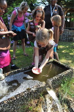 USA Girl Scouts Overseas play in the water during their field trip to the water treatment facility, June 13, 2013, Ramstein Air Base, Germany. The 786th Civil Engineer Squadron tests and purifies the drinking water for the KMC to ensure the distributed water is consumable for Airmen and civilians on base. (U.S. Air Force photo/Airman 1st Class Dymekre Allen)