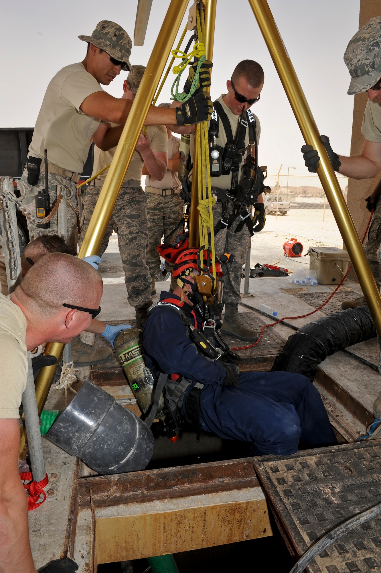 Airman 1st Class Devin Walsh is lowered into one of the installation?s largest sewage lift stations to repair a pump at the 379th Air Expeditionary Wing in Southwest Asia, June 18, 2013. Walsh is a 379th Expeditionary Civil Engineer Squadron water and fuel systems maintenance technician deployed from Elmendorf AFB, Alaska. (U.S. Air Force photo/Senior Airman Benjamin Stratton)