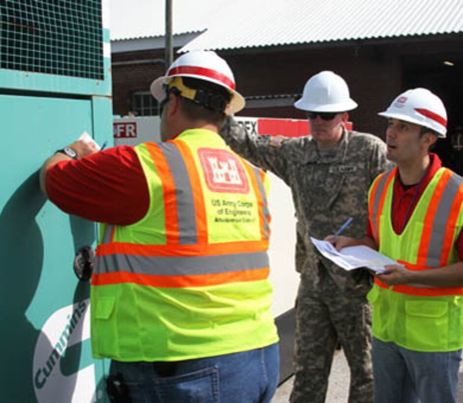 Joseph Rael (right) and Kelly Adams (left) of the Emergency Power team check to ensure a generator is ready for installation during the Combined Response Mission Exercise in Philadelphia. Staff Sgt. James Phillips of the 249th Prime Power Battalion observes.