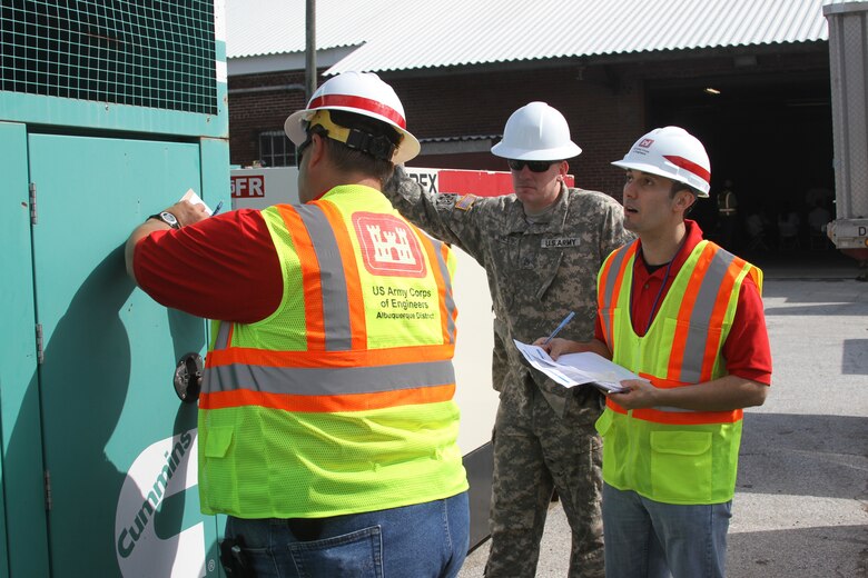 Joseph Rael (right) and Kelly Adams (left) of the Emergency Power team check to ensure a generator is ready for installation during the Combined Response Mission Exercise in Philadelphia. Staff Sgt. James Phillips of the 249th Prime Power Battalion observes activities. 