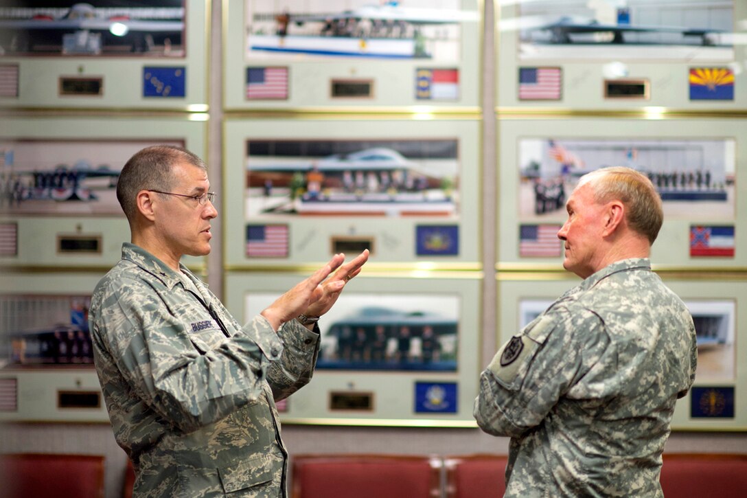 Air Force Brig. Gen. Thomas A. Bussiere, left, commander of the 509th Bomb Wing, briefs Army Gen. Martin E. Dempsey, chairman of the Joint Chiefs of Staff, about B-2 bomber operations and maintenance on Whiteman Air Force Base, Mo., June 18, 2013. 