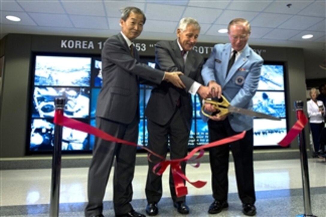 Secretary of Defense Chuck Hagel, center, Korean Ambassador to the United States Ahn Ho-young, left, and National Director of the Korean War Veterans Association Lew Ewing, cut the ribbon to open a new display commemorating the Korean War in the Pentagon in Arlington, Va., on June 18, 2013.  Hagel earlier thanked the Korean War veterans for attending the ceremony and emphasized that the war and their service will never be forgotten.  