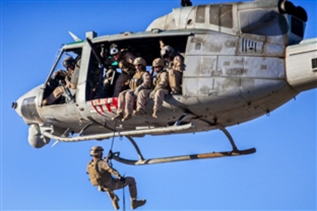 A U.S. Marine rappels from a UH-1N Huey helicopter during a rope exercise as part of Eager Lion 2013 on King Faisal Air Base, Jordan, June 11, 2013. The multinational exercise is designed to strengthen military-to-military relationships, and enhance security and stability in the region by responding to modern-day security scenarios. The helicopter is assigned to Marine Medium Tiltrotor Squadron 266.